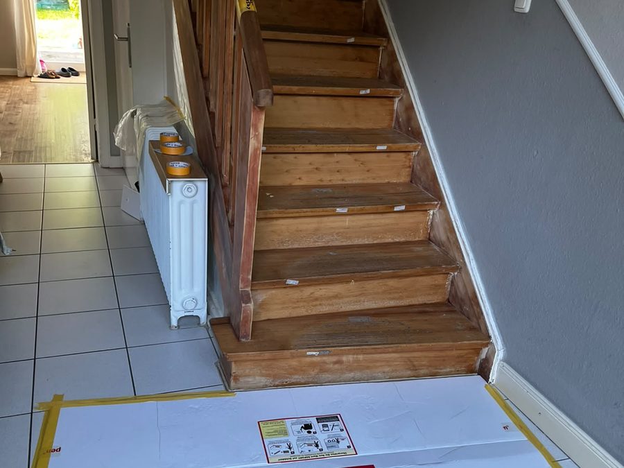 Treppe vor Beginn der Arbeiten, Boden mit Schutzmatte abgedeckt