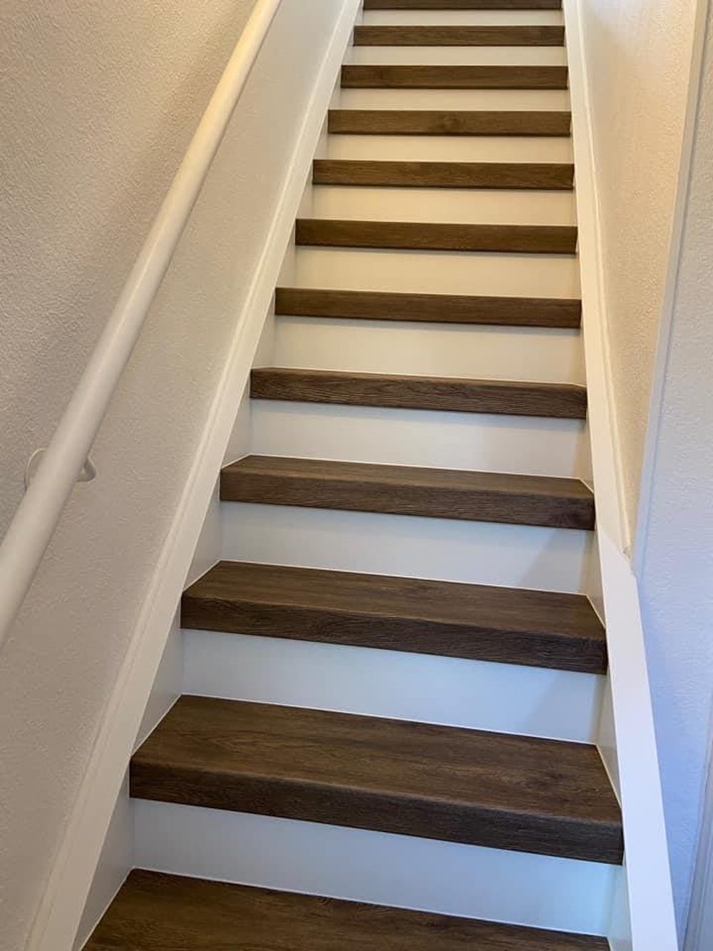 Die renovierte Treppe mit dunklen Trittstufen und hellen Stellstufen