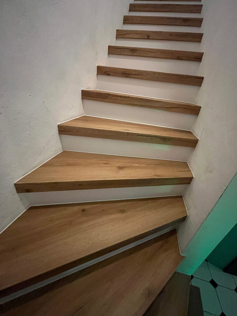 Die renovierte Betontreppe mit hellen Holzstufen und sauberen Kanten