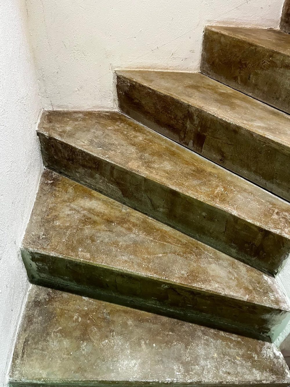 Verwitterte Betontreppe mit moosigem Belag und abgeplatzten Kanten