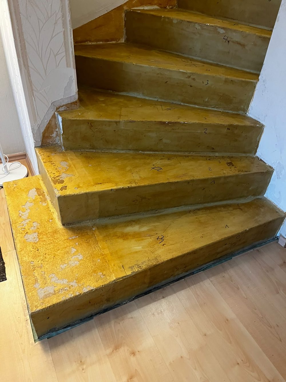 Alte, gelb gestrichene Betontreppe mit abgenutzten Stufen vor der Renovierung