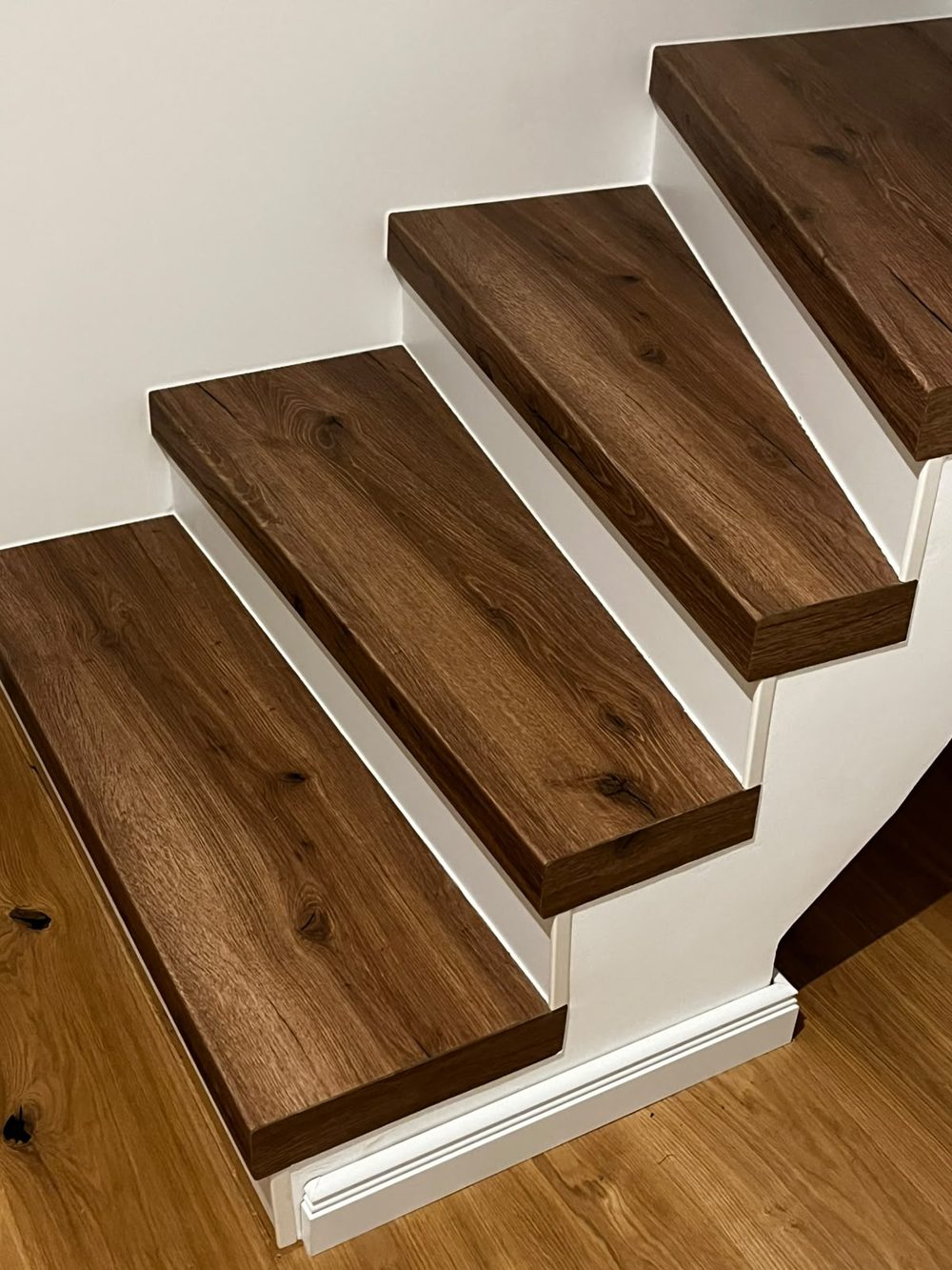 Die renovierte Steintreppe mit warmen Holzstufen auf dem alten Unterbau